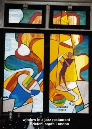 4 Paneled window depicting Sax player in spotlight, cleft lines emanating from saxophone to differing destinations.