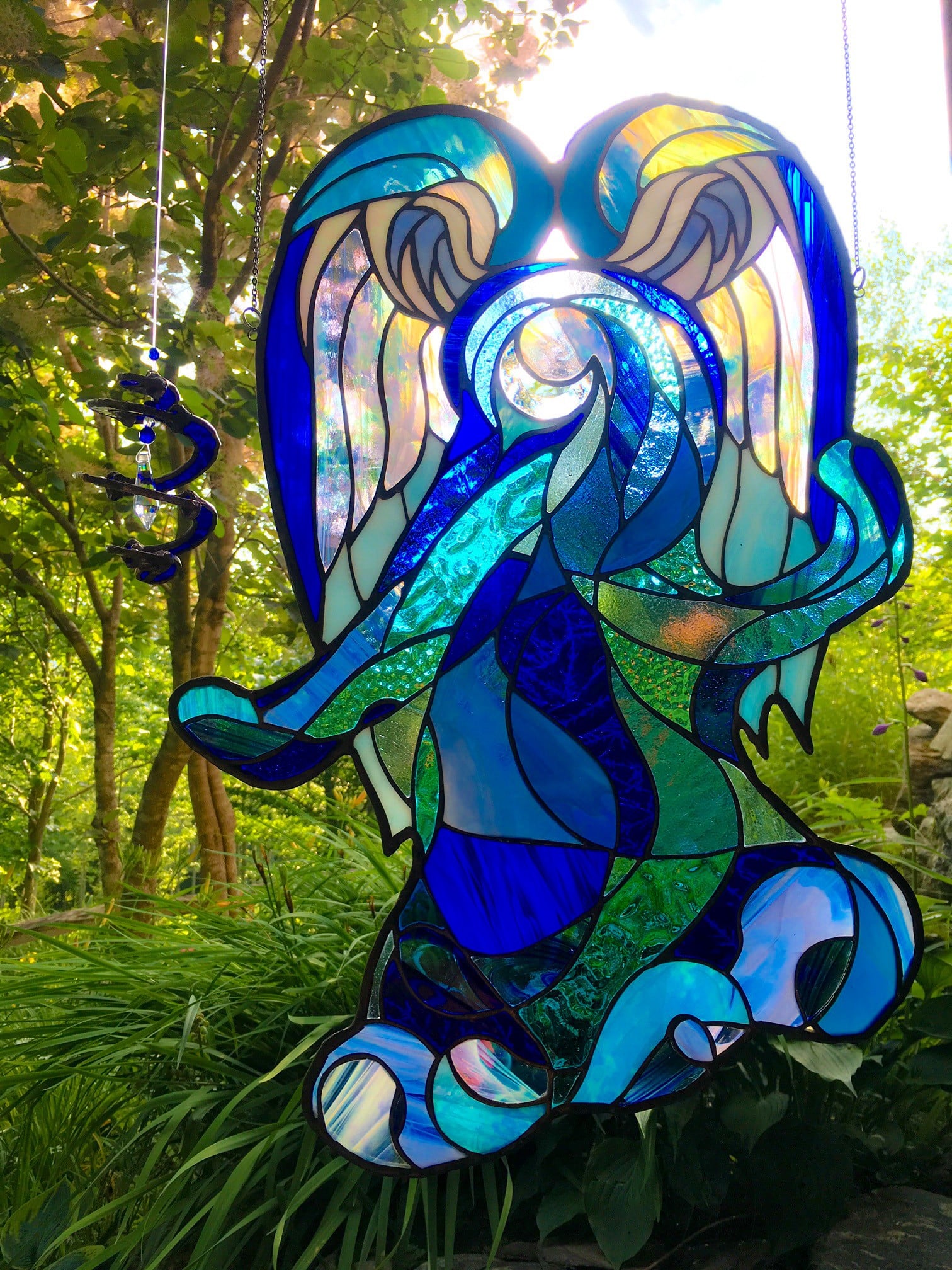 antithesis of classic angel depictions, Bella is a swirling menagerie of blue stained glass, more of an energy than a form.